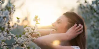 Glück Symbolbild - Frau freut sich an Frühlingsblumen