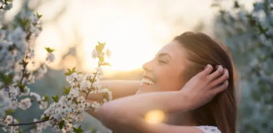 Glück Symbolbild - Frau freut sich an Frühlingsblumen