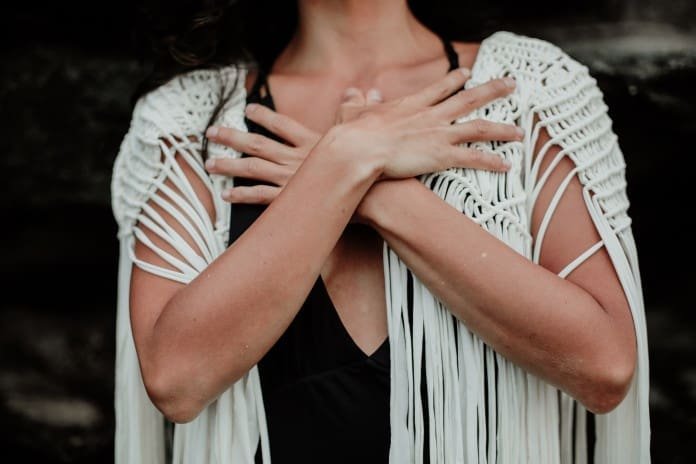 Hände vor dem Herz Frau weißer Cardigan Herz Meditation Yogaworld