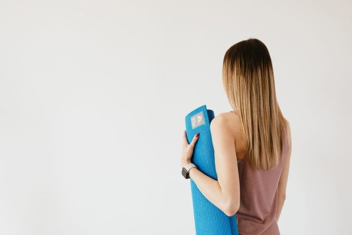 Frau mit Yogamatte