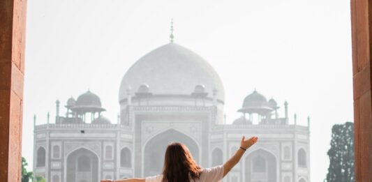 Frau steht vor Taj Mahal in iIndien