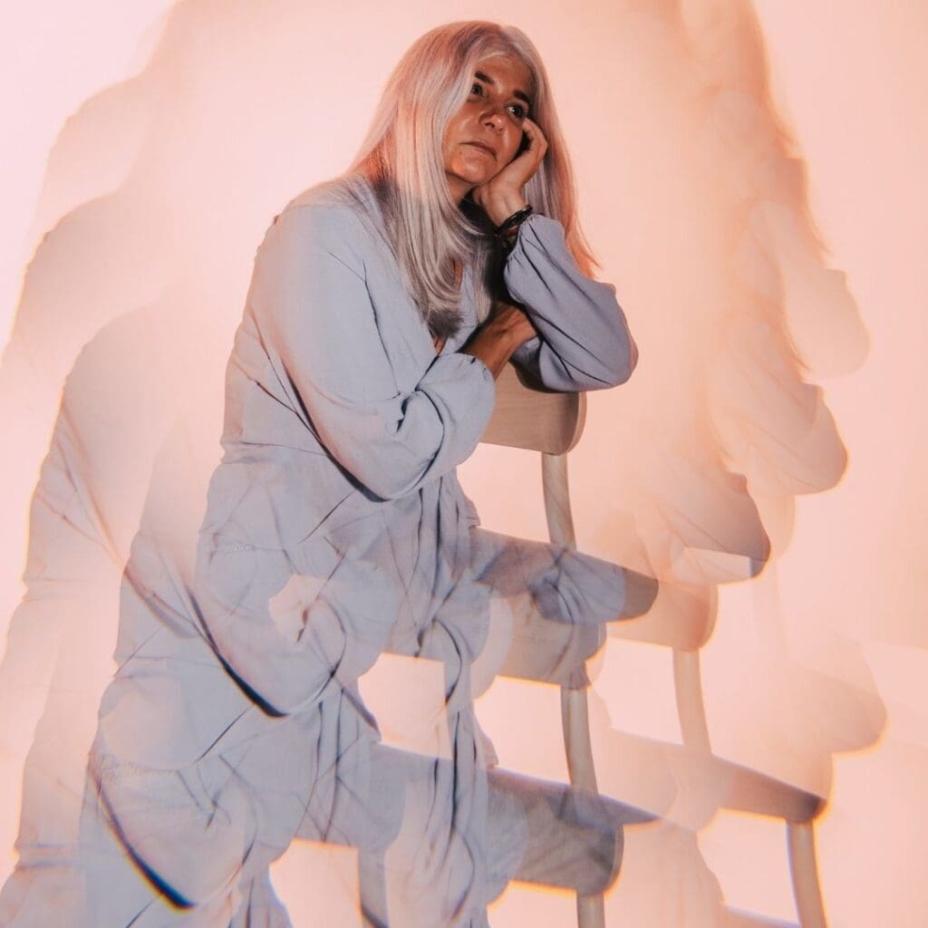 Yoga bei Parkinson Symbolbild, verwackelte Frau sitzt auf einem Stuhl, somedazeare von baseimage