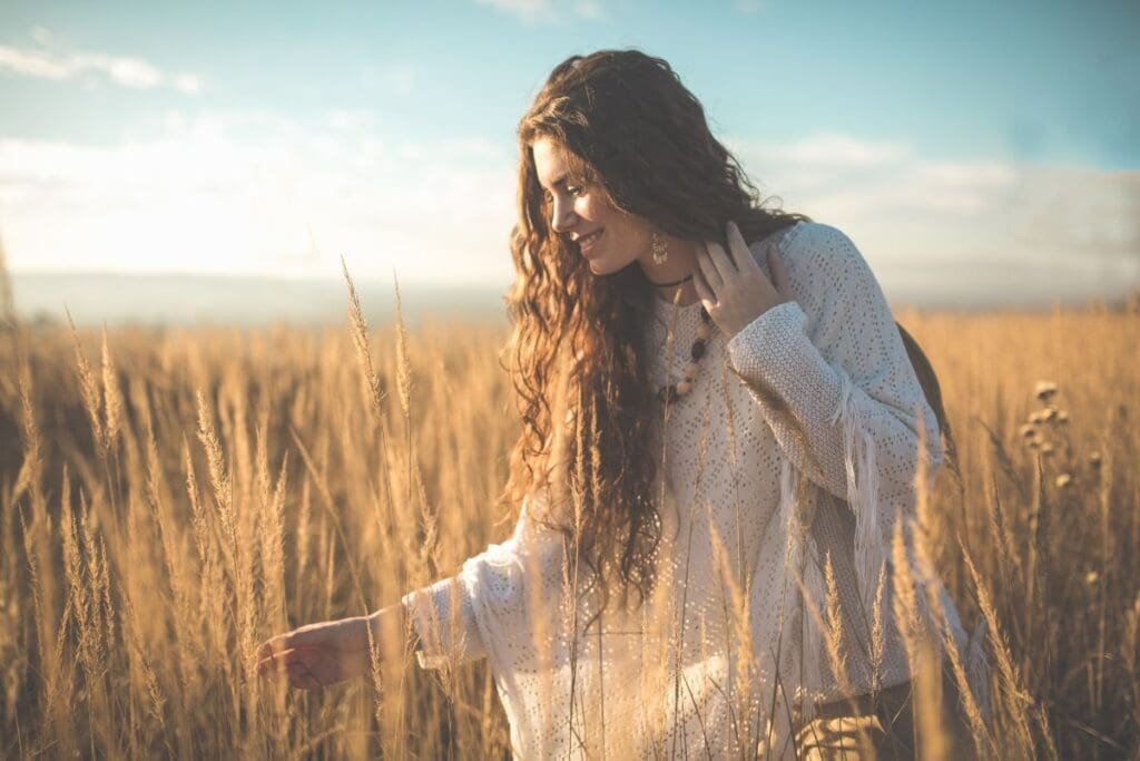 Ernte Symbolik Frau steht auf Feld und bewundert Ähren