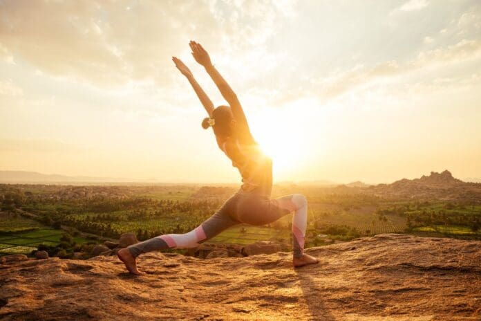 Krieger Yogapose in der Sonne Hampi Tempel
