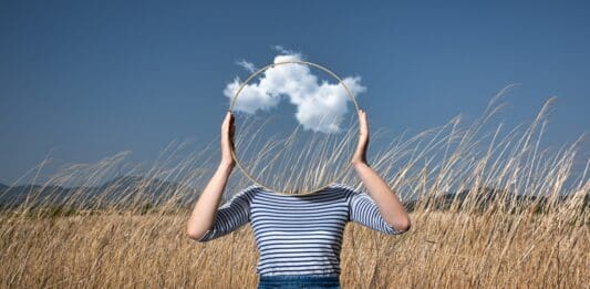 frau hält spiegel vor gesicht