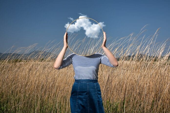 frau hält spiegel vor gesicht