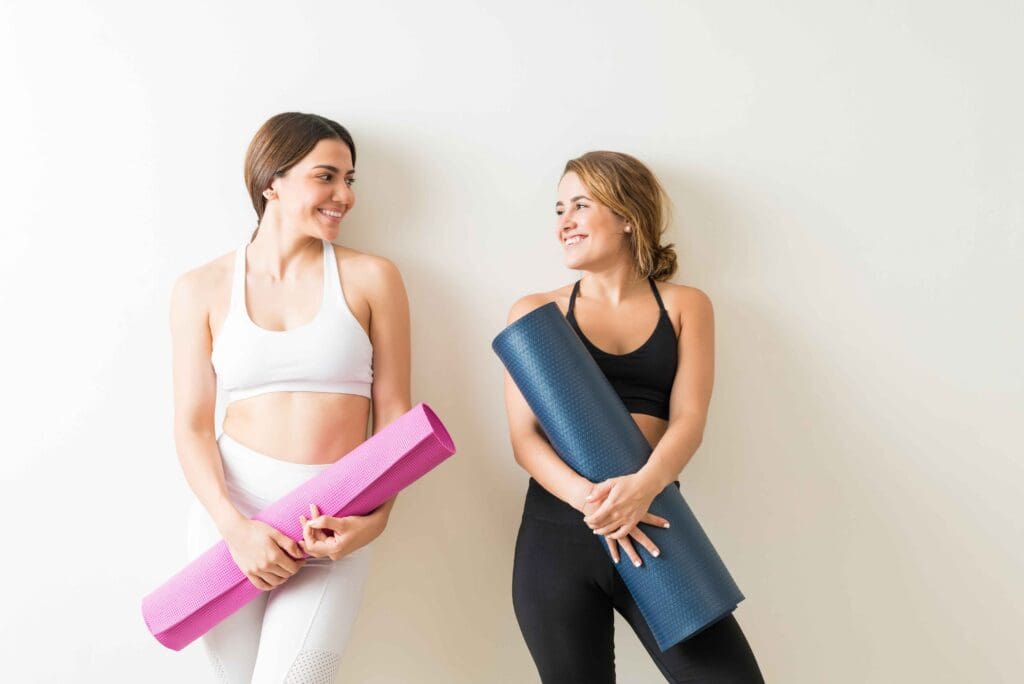 zwei Frauen mit Yogamatten, Symbolbild, Antonio_Diaz von Getty Images
