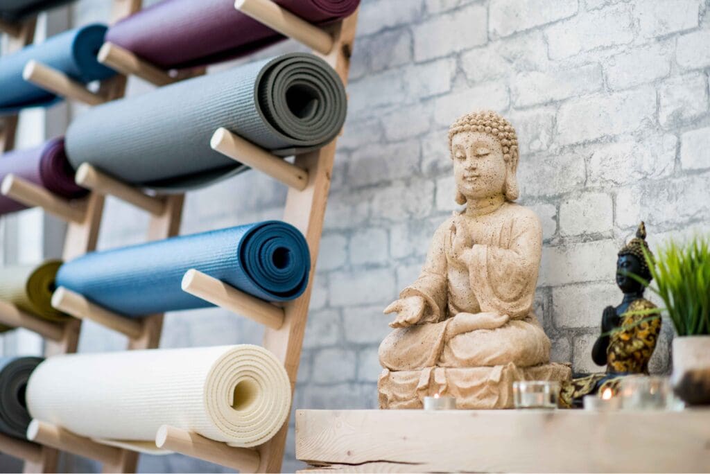 aufgeräumte Yogamatten im Regal und Buddhafiguren, Symbolbild, FatCamera von Getty Images Signature