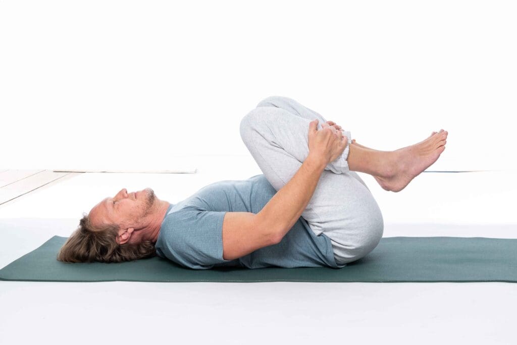 Patrick Broome, Knie zur Brust, Yogaübung, Sonnenpraxis