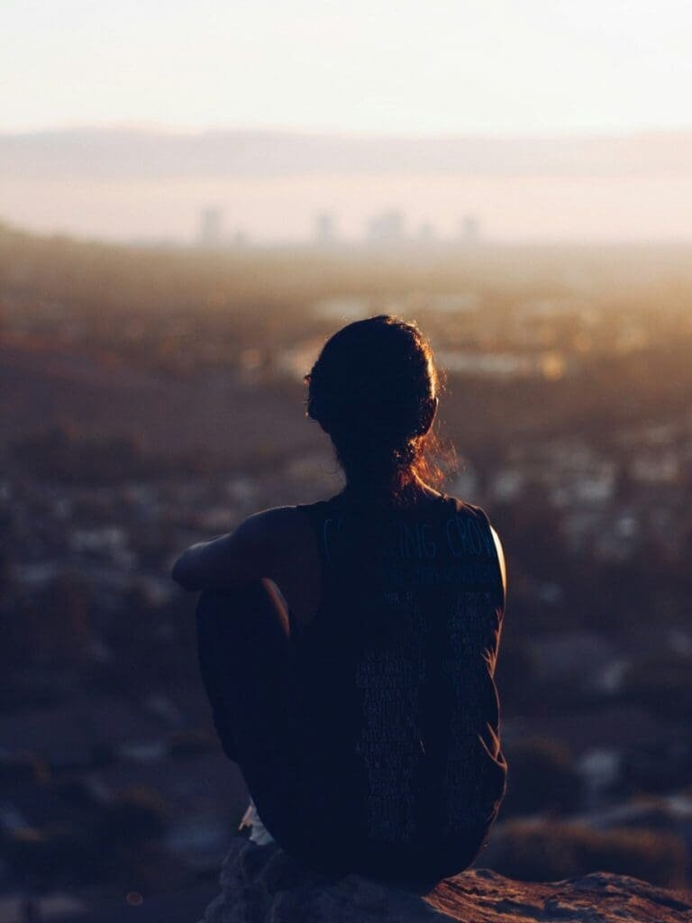 Frau alleine sitzend mit Blick in die Ferne