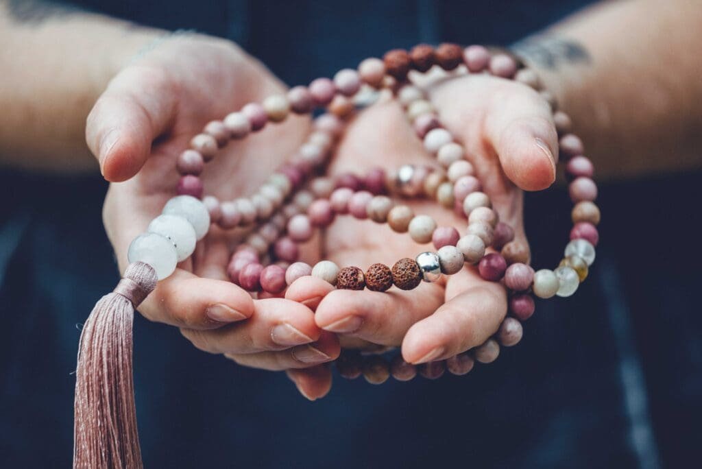 Hände mit Mala-Kette, Meditation, Symbolbild, Credit: Aden Vale von Getty Images Signature via Canva