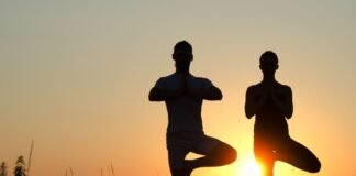 Pärchen macht Yoga vor Sonnenuntergang