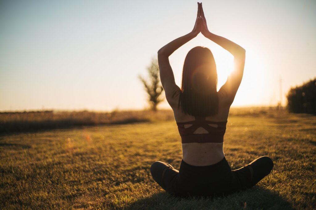 Frau begrüßt Morgensonne und macht Yoga