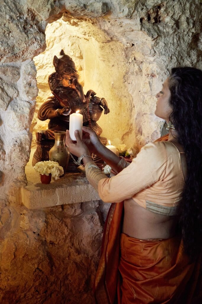 Salisha Aya lässt bei der Puja eine Kerze vor ihrem Altar kreisen. Foto: Nela König