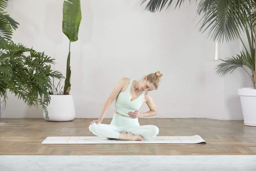 Dr. Svenja Borchers, sitzende Seitbeuge mit Hand auf den Rippen, Neurozentriertes Yoga Koordination, Fotocredit: Nela König